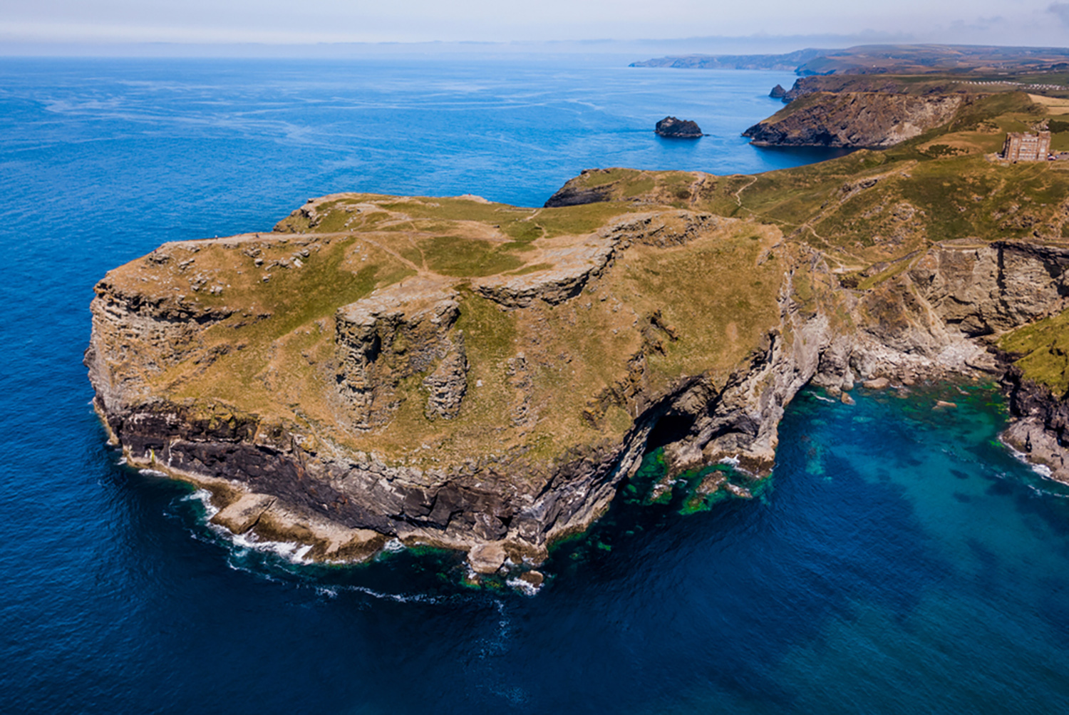 Aerial view of Tintagel Castle on its island headland above the Atlantic, North Cornwall