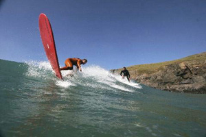 Surfing in Holywell Bay