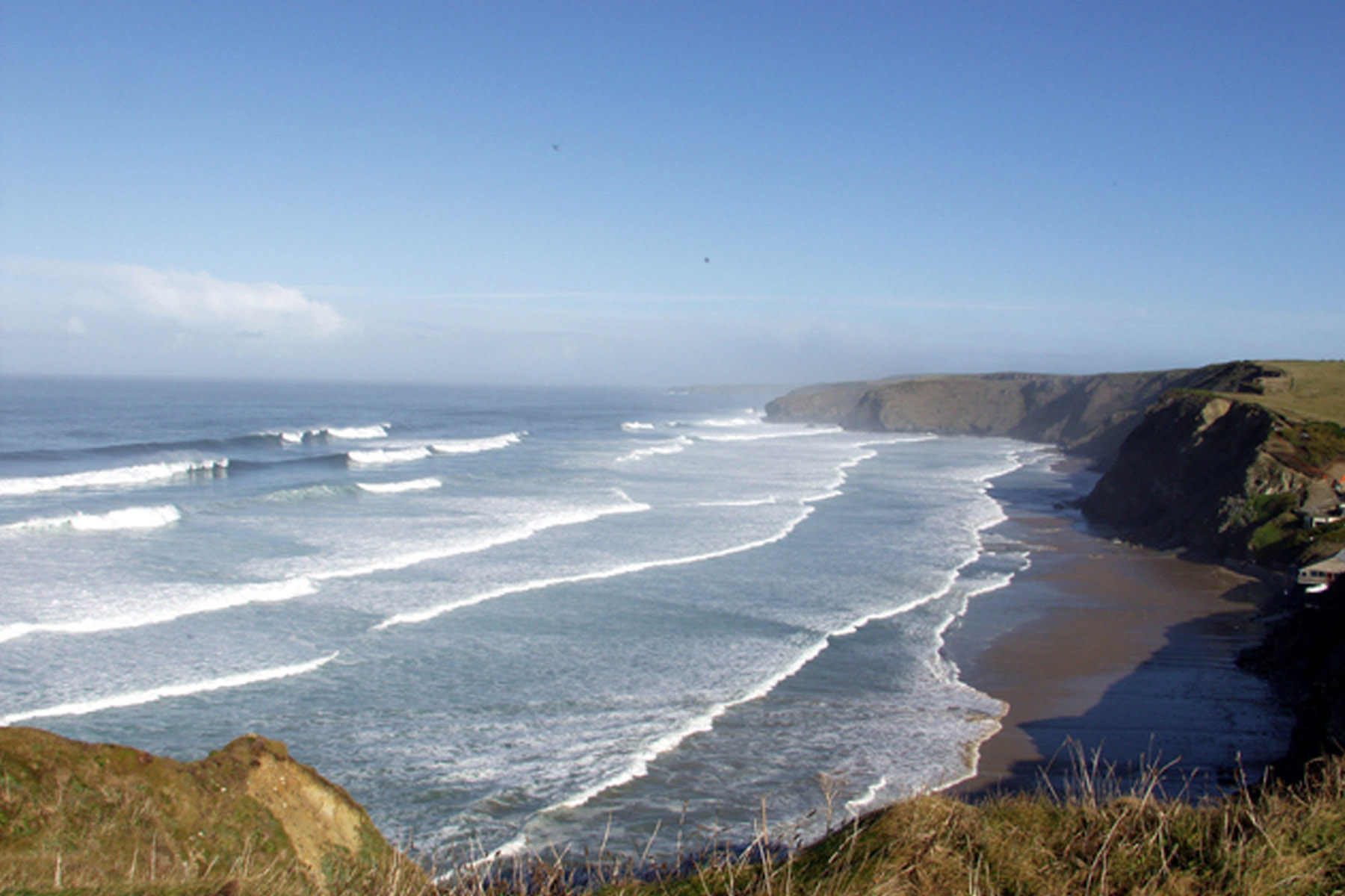 Surf rolling into Whipsiderry and the coast towards Watergate Bay