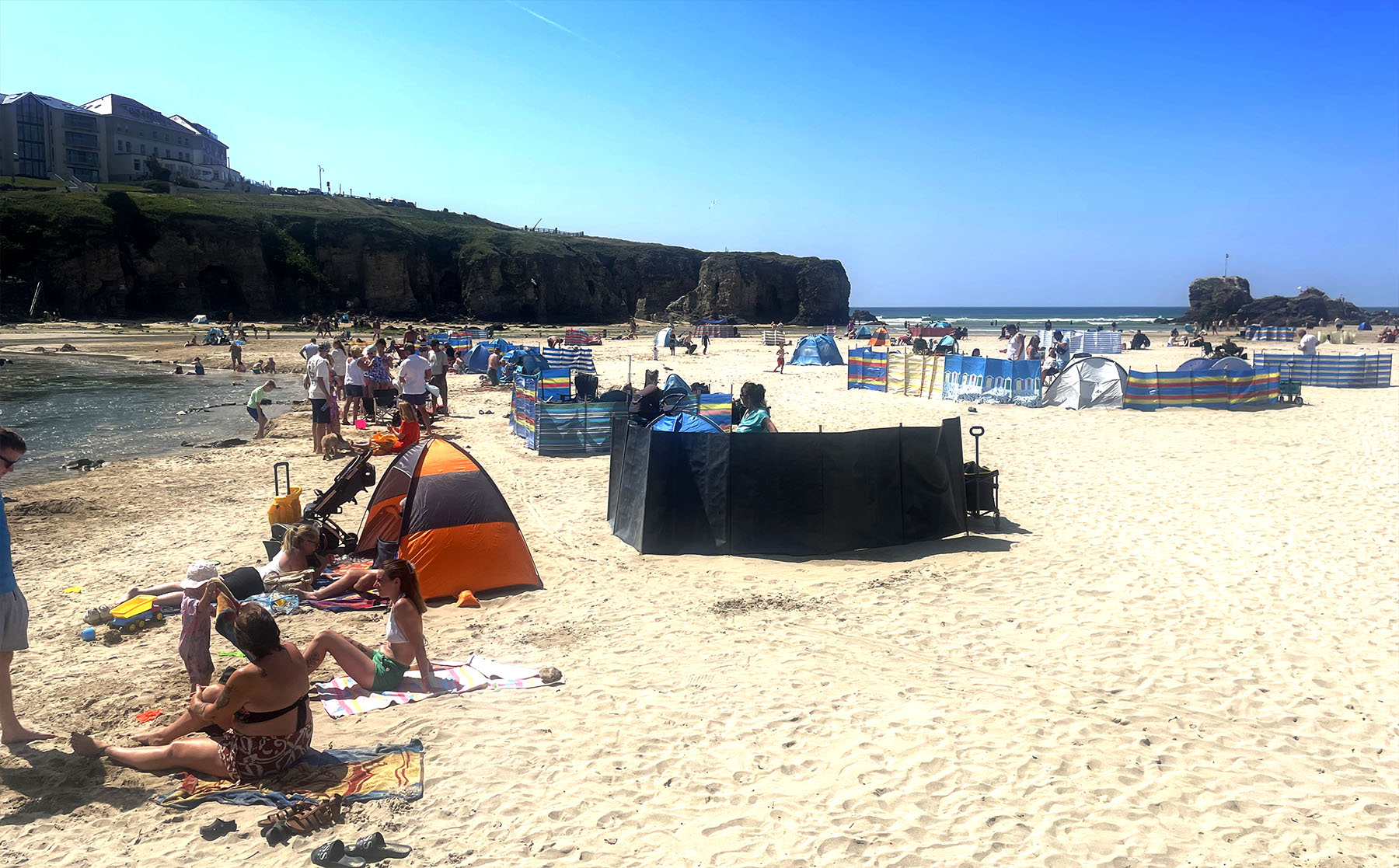 Perranporth Beach families relaxing beside the stream in the summer holidays - Cornwall family beach holidays